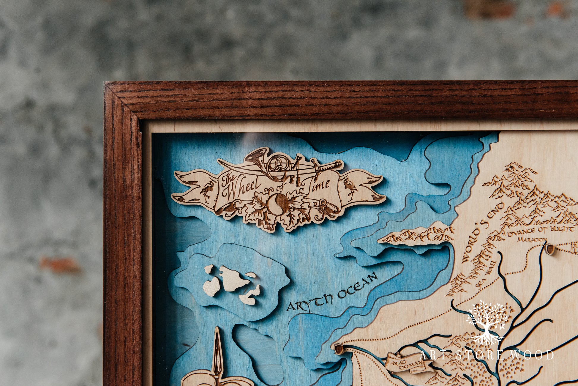 Close-up laser-cut detail on The Wheel of Time 3D wooden map showing terrain layers