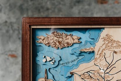 Close-up laser-cut detail on The Wheel of Time 3D wooden map showing terrain layers